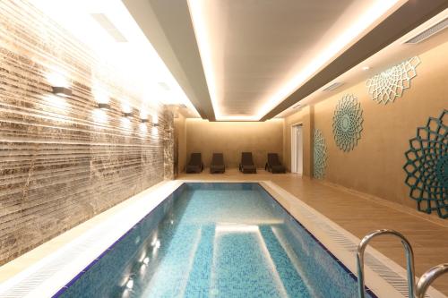 a swimming pool in a hotel with a tile wall at Classy Suite Taksim in Istanbul