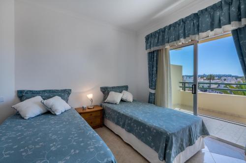 1 dormitorio con 2 camas y ventana con vistas en AL - Maré, en Albufeira