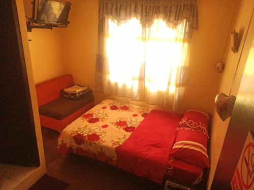 ein kleines Schlafzimmer mit einem Bett und einem Fenster in der Unterkunft Hostal Globo in Quito