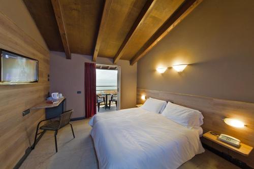 a bedroom with a bed and a table and a window at Hotel La Paül in Sirmione