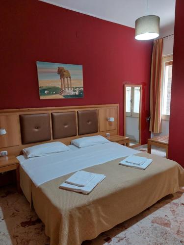 - une chambre avec un grand lit aux murs rouges dans l'établissement CASA VACANZE LINA, à San Mauro Castelverde
