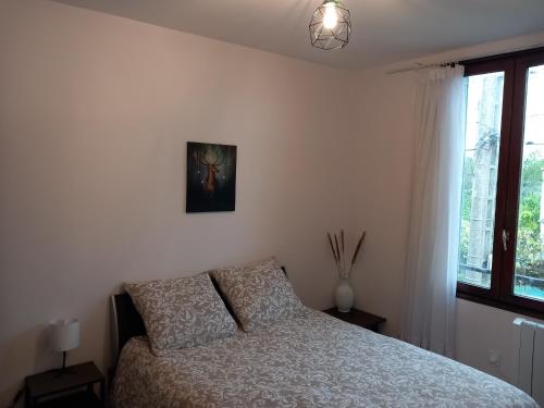 1 dormitorio con 1 cama y una foto en la pared en Beau F2 à 5 mn de l'aéroport d'Orly, en Paray-Vieille-Poste