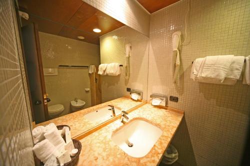 a bathroom with a sink and a toilet and a mirror at Hotel La Paül in Sirmione