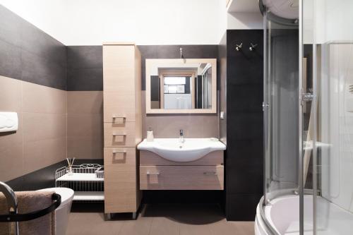 W łazience znajduje się umywalka, lustro i prysznic. w obiekcie Attic Vatican Flat - San Pietro w Rzymie