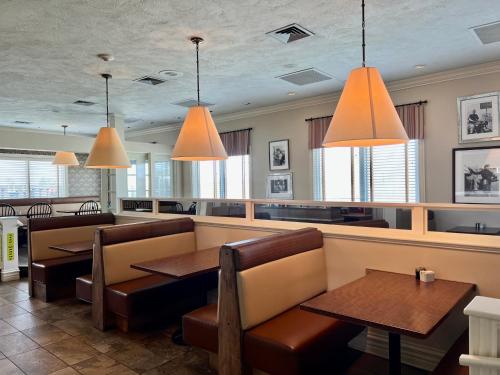 a restaurant with tables and chairs and pendant lights at Atlantic Host Hotel, Trademark Collection by Wyndham in Bathurst