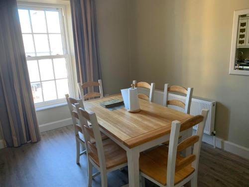 a dining room with a wooden table and chairs at Cuckoos Corner in Teach Munna