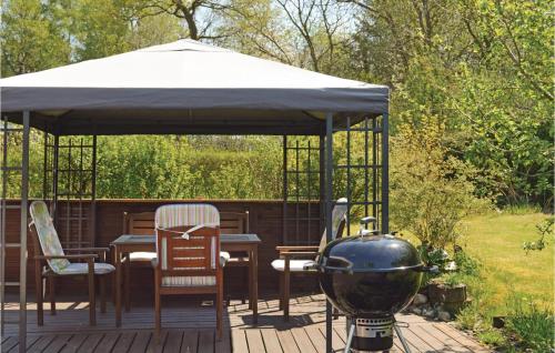 a gazebo with a grill and chairs on a deck at 3 Bedroom Cozy Home In Fårvang in Fårvang