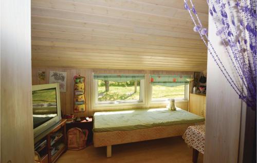 Fårvangにある3 Bedroom Cozy Home In Frvangのベッド1台とテレビが備わる小さな客室です。