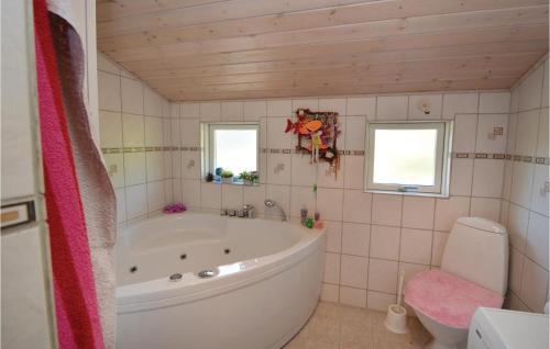 FårvangにあるAmazing Home In Frvang With 3 Bedrooms, Wifi And Outdoor Swimming Poolのバスルーム(大型バスタブ、トイレ付)