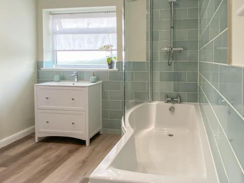 a bathroom with a tub and a sink at Lily J Rose in Braunston