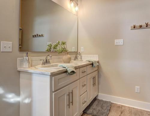 a bathroom with two sinks and a large mirror at Youngsville Sports Complex NEW Townhome in Youngsville