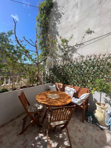 a wooden table and chairs on a patio at Oleander Apartment & Room Centar in Hvar
