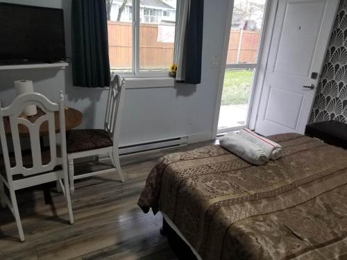 a bedroom with a bed and a chair and a window at Guest Suite Private Retreat for 2 Guests With AC - 4 Units Available in Abbotsford