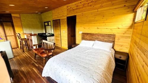 a bedroom with a bed in a wooden room at Eco Cabañas del Encanto, La Calera in La Calera