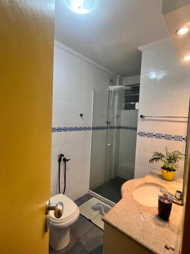a bathroom with a toilet and a sink and a shower at Nosso apê no Guarujá - Unidade Aquário in Guarujá