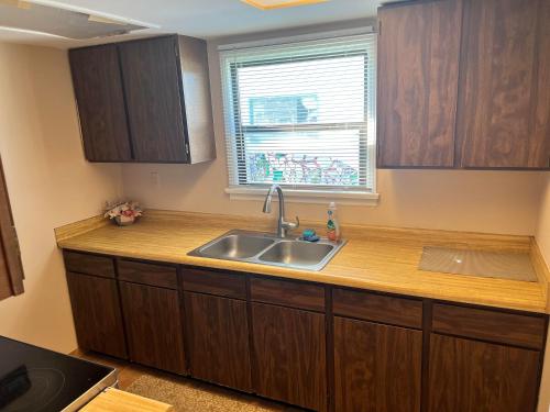 a kitchen with a sink and a window at Great House Motel in Sequim