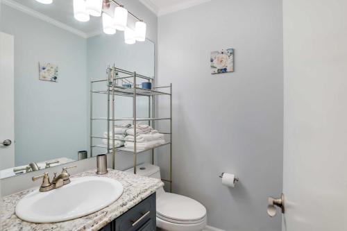 La salle de bains est pourvue d'un lavabo, de toilettes et d'un miroir. dans l'établissement North Charleston Vacation Rental Near Cooper River, à Charleston