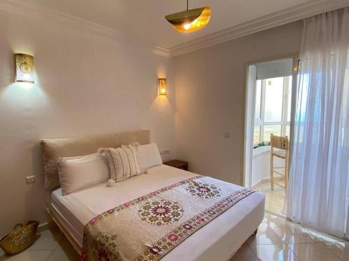 a bedroom with a large bed and a balcony at Nice apartment beach front, close to Rabat main sightseeing. Fiber WiFi in Rabat