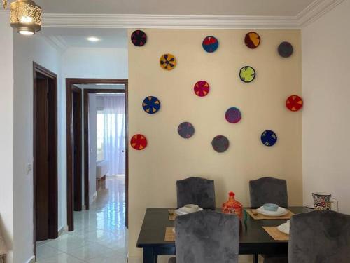 a dining room with a table and clocks on the wall at Nice apartment beach front, close to Rabat main sightseeing. Fiber WiFi in Rabat