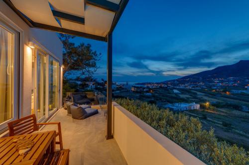a balcony with a table and a view of a city at Villa Mare Syros in Finikas