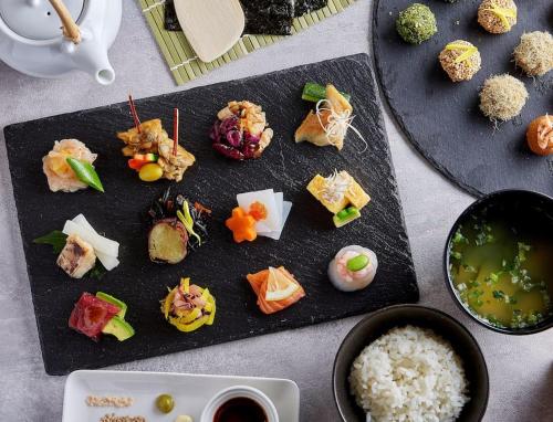 a bunch of food on a black plate with rice at 403 Oshiage sta 3mins walk! Wi-Fi & Elevator 4pax in Tokyo