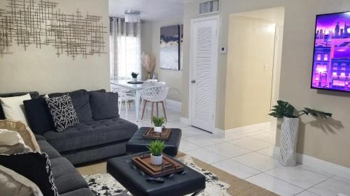 a living room with a couch and a table at Glam 2 Bedroom Apartment Close to NSU in Cooper City in Cooper City