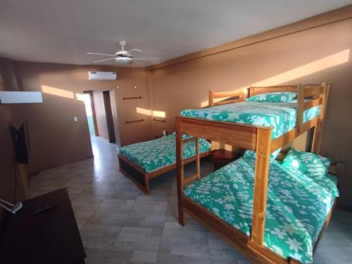 two bunk beds in a room with a ceiling at The Lookout Beach Hotel in San Lorenzo