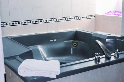 La salle de bains est pourvue d'un lavabo bleu et d'une serviette. dans l'établissement Hotel Paquime, à Nuevo Casas Grandes
