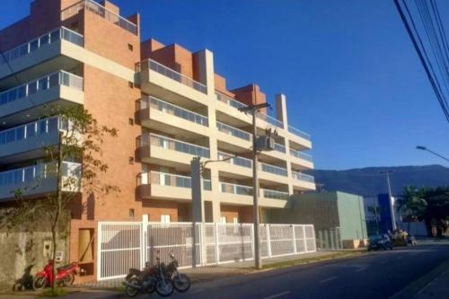 a large building with motorcycles parked in front of it at Apto. com varanda gourmet e piscina aquecida in Bertioga