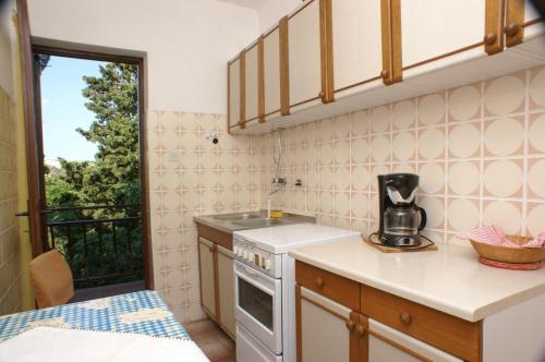 una piccola cucina con lavandino e piano cottura di Apartments by the sea Stara Novalja, Pag - 4153 a Novalja (Novaglia)