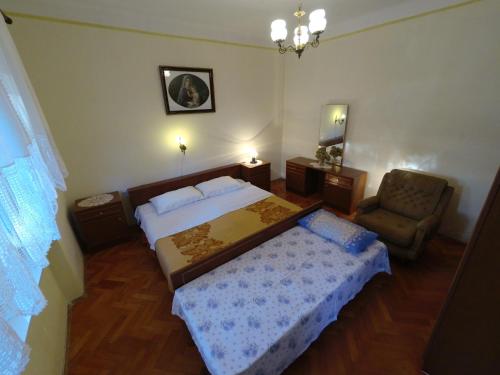 una camera con letto e sedia di Apartments by the sea Stara Novalja, Pag - 4153 a Novalja (Novaglia)