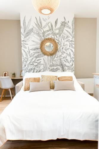- une chambre avec un lit blanc et une fresque murale dans l'établissement Le naturel - Superbe logement - Extérieur privatif - Centre ville, au Mans