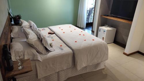 łóżko z białym kocem i kwiatami w obiekcie Solar dos Ipês w mieście Serra do Cipo