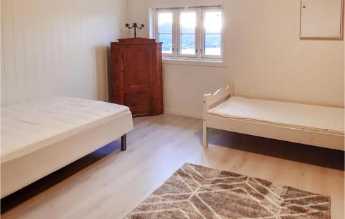 1 dormitorio con 2 camas y ventana en Gorgeous Apartment In Lyngdal With Kitchen, en Lyngdal
