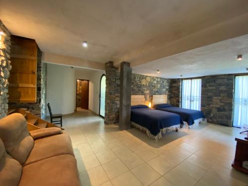 1 Schlafzimmer mit 2 Betten und einem Sofa in der Unterkunft Casa Camino a las Pozas in Xilitla