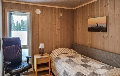 a bedroom with a bed and a chair and a window at Beautiful Home In Lillehammer With Sauna in Lillehammer