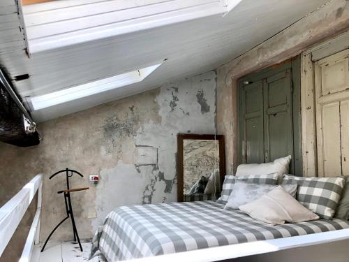 a bedroom with a bed and a window and a mirror at Charming and Design Attic Loft Central Milan in coolest area Navigli Ticinese in Milan