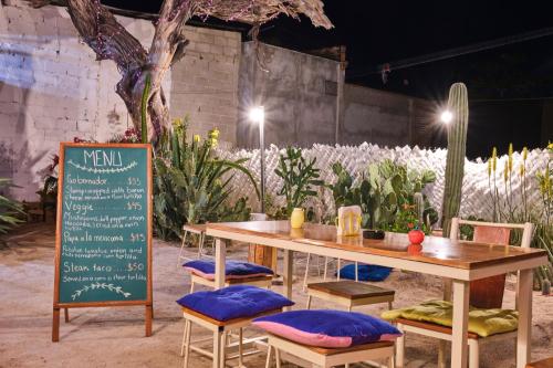 a table and chairs with a menu and a sign at Hostel Casa Esterito in La Paz