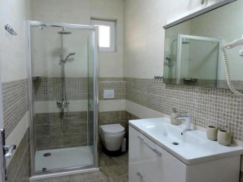 ein Bad mit einer Dusche, einem Waschbecken und einem WC in der Unterkunft Apartments by the sea Preko, Ugljan - 21319 in Preko