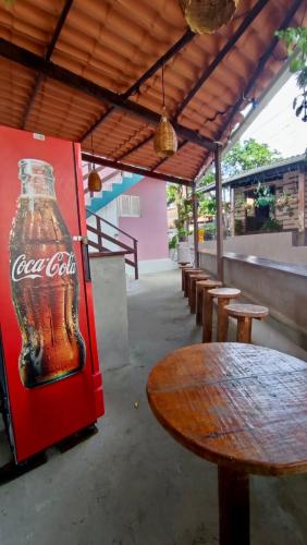 een oude Coca-Cola-fles die naast een Coca-Cola-automaat staat bij NORDESTINA PiPA in Pipa