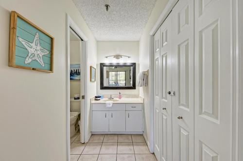 W łazience znajduje się umywalka i lustro. w obiekcie Gulf Breeze Ami-2BD-2BA-Condo-Private Beach Access-Heater Pool-Water Views From Every Window w mieście Bradenton Beach