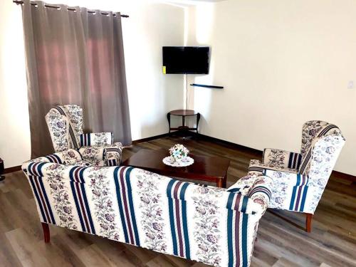 a living room with a couch and two chairs at Cheerful 2-bedroom home with patio near city center in Willemstad