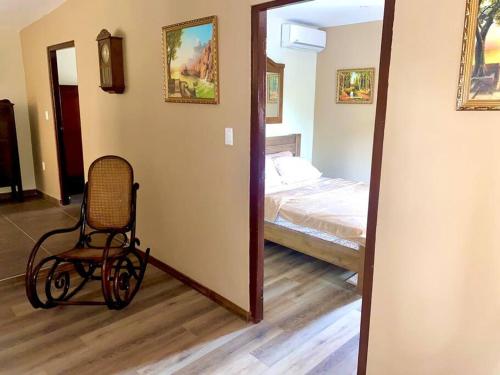 ウィレムスタッドにあるCheerful 2-bedroom home with patio near city centerの椅子、ベッド、鏡が備わる客室です。