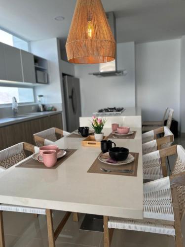 una cocina con una mesa con tazones y platos. en Luxury Aparment in Reserva del Mar, en Gaira