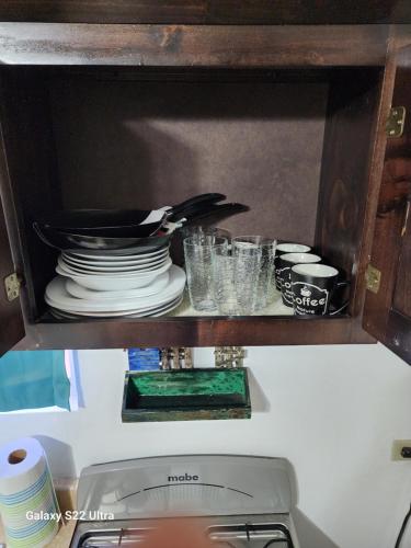 a kitchen cabinet with plates and dishes in it at Guest house 2 mins from da beach in Puerto Peñasco