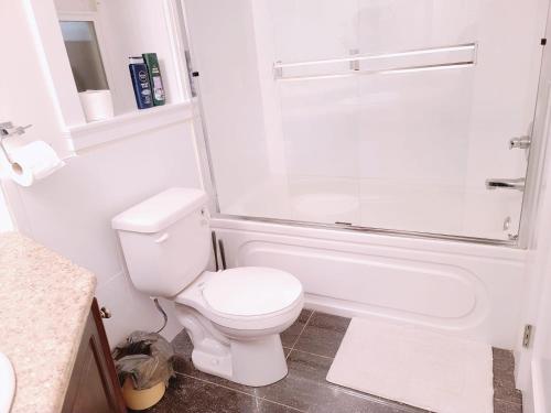 a white bathroom with a toilet and a shower at Peaceful Private Room in Surrey