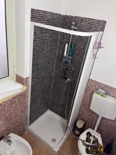 a bathroom with a shower with a toilet and a sink at Villino luca in Isola delle Femmine