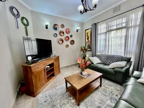 sala de estar con sofá y TV en The Angelique Oasis en Arusha