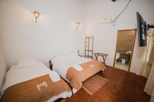 a bedroom with two beds with towels on them at Hotel Archangelus in Mompós