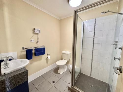 a bathroom with a shower and a toilet and a sink at Moura Motel in Moura